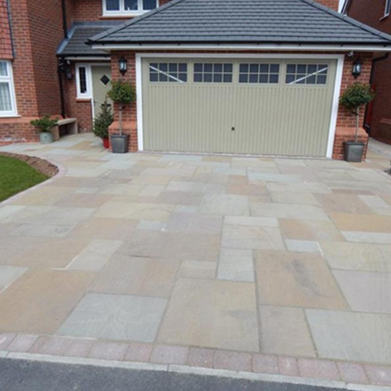 Driveways Paved driveway in front of a garage, with brick edging and potted plants.